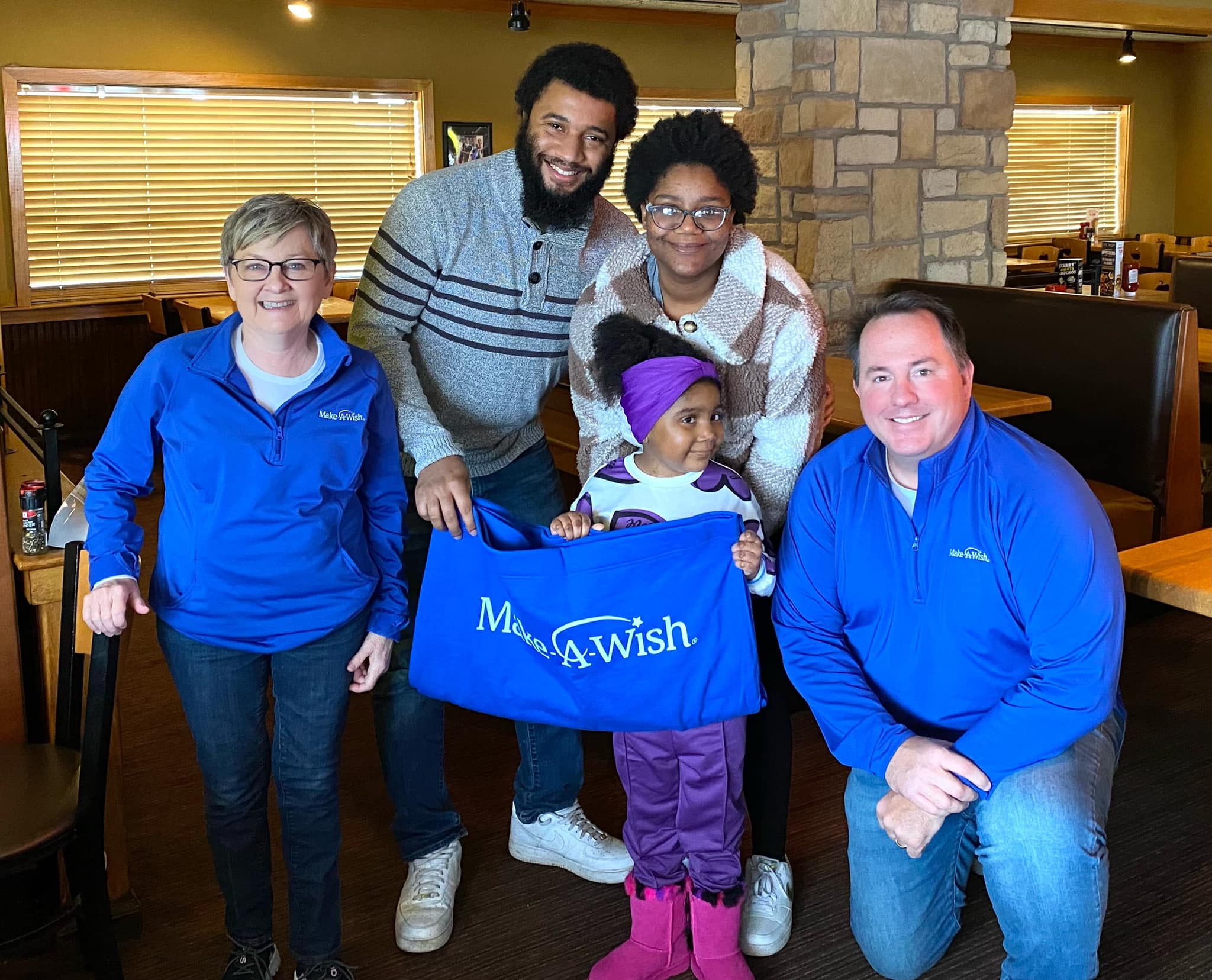 Pam (left) and Corey (far right) with wish kid Kai and her parents Malik and Kaila. The Schielers have been wish granting volunteers since 2010, granting more than 40 wishes.